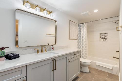 a bathroom with a sink and a toilet and a mirror at Bellevue Splendor Fern Suite BY Betterstay in Bellevue