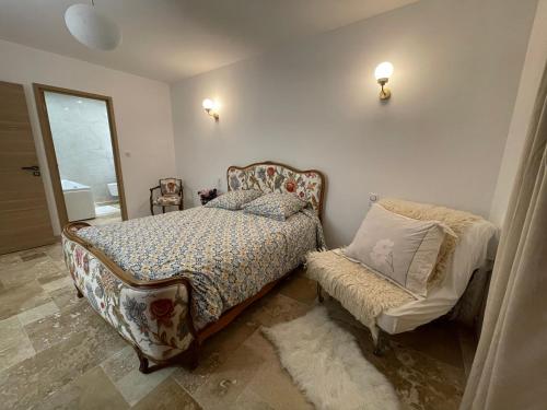 una camera da letto con un letto e una sedia di Villa Segny a Ségny