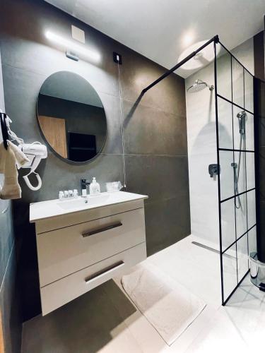 a bathroom with a sink and a shower with a mirror at MOZAIK APARTMENTS & SPA - Modern 4-Star Apartments with Exclusive Private SPA WELLNESS in the City Center - SAUNA, JACUZZI, TURKISH BATH - FREE PARKING, Wi-FI - Rooms & Apartments Cuprija in Ćuprija