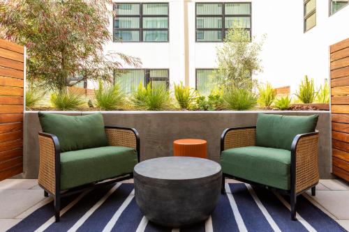 two chairs and a coffee table on a patio at Kissel Uptown Oakland, in the Unbound Collection by Hyatt in Oakland