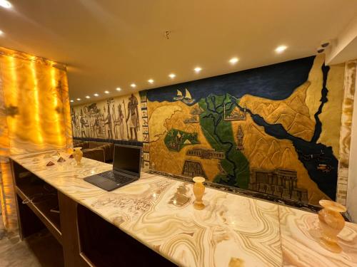 a laptop on a counter with a mural on the wall at King Pyramids View Hotel in Cairo