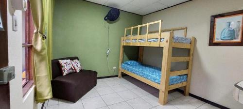 um quarto com 2 beliches e uma cadeira em Hospedaje Doña koko em Puerto Limón