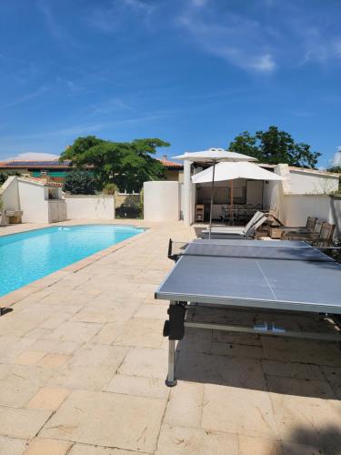 - une table de ping-pong à côté de la piscine dans l'établissement Gîte élégant au calme, à Mazan