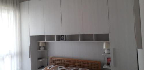 une cuisine avec des placards blancs et une cheminée en briques dans l'établissement 250 m dalla spiaggia! Spiaggia libera o attrezzata - LA CASA DI KATE, à Grado