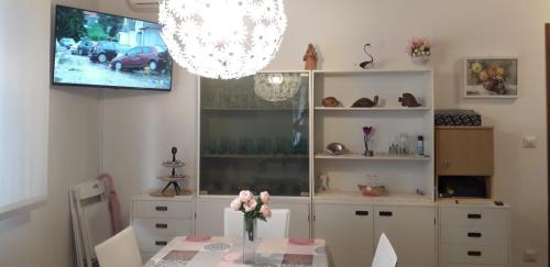 une salle à manger avec une table avec un vase de fleurs dans l'établissement 250 m dalla spiaggia! Spiaggia libera o attrezzata - LA CASA DI KATE, à Grado