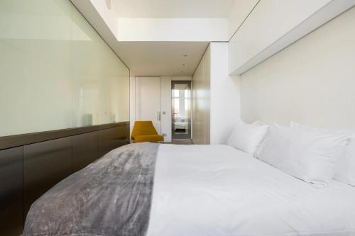 a bedroom with a large white bed and a mirror at The Tonic in Shoreditch in London