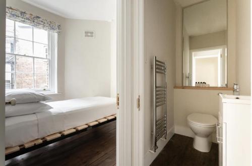 a bedroom with a bed and a toilet and a window at 3 Bedroom in the Heart of West End in London