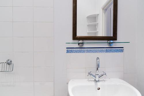 a white bathroom with a sink and a mirror at PER-64 64 Perham Road in London