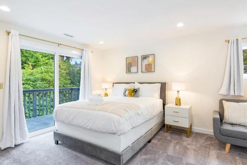 a white bedroom with a bed and a balcony at Cul-de-Sac Comfort BY Betterstay in Bellevue