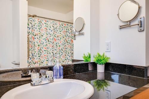 a bathroom with a sink and two mirrors at Eastgate Rambler BY Betterstay in Bellevue