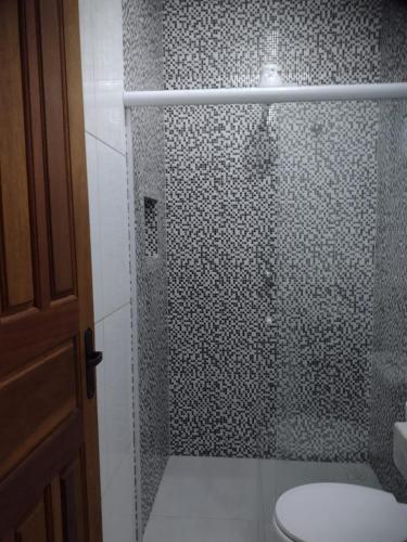 a bathroom with a glass shower with a toilet at Pouso AJH in Paraty