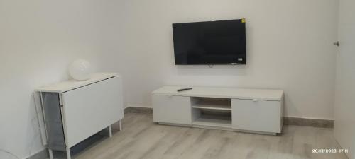 a white living room with a tv on a wall at Apartamento Agradables 3 in Madrid