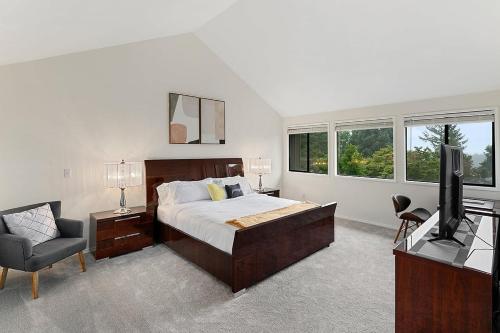 a bedroom with a bed and a television and a chair at Highland Haven BY Betterstay in Bellevue