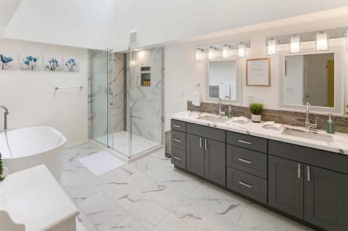 a bathroom with two sinks and a tub and a shower at Highland Haven BY Betterstay in Bellevue