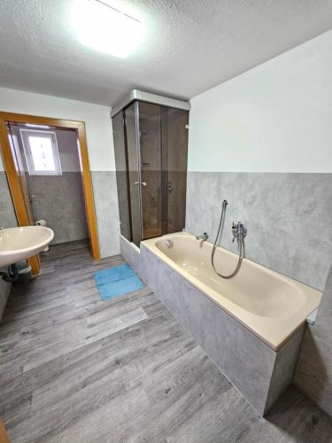 a bathroom with a bath tub and a sink at Haus Mitten in Herzen von Günzburg in Günzburg