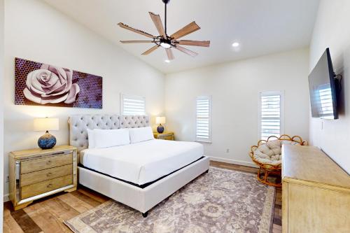 a bedroom with a white bed and a ceiling fan at Corpus Christi's Charmer in Corpus Christi
