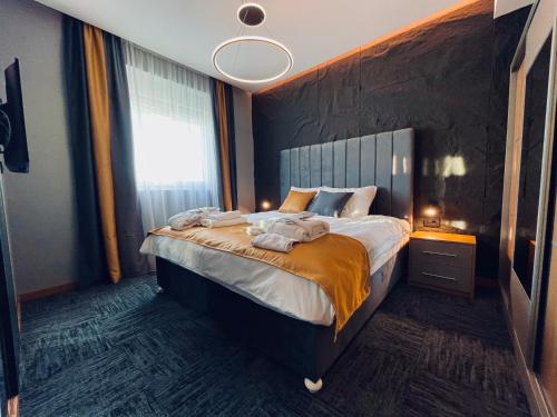 a bedroom with a bed with towels on it at MOZAIK APARTMENTS & SPA - Modern 4-Star Apartments with Exclusive Private SPA WELLNESS in the City Center - SAUNA, JACUZZI, TURKISH BATH - FREE PARKING, Wi-FI - Rooms & Apartments Cuprija in Ćuprija