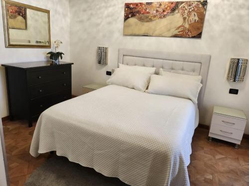 a bedroom with a white bed and a black dresser at Villa Florencia in Boca Chica