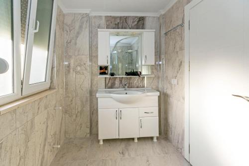 a bathroom with a white sink and a mirror at Paradise Town Villa Legend in Belek