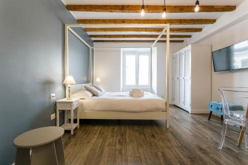 Un dormitorio con una cama, un televisor y una mesa. en Navigli - Vigevano 45 & Casale 3a studios, en Milán