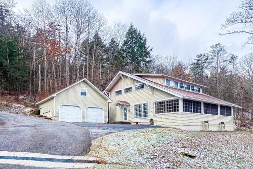 a white house with a garage and a driveway at The Cave Inn in Bomoseen