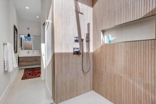 y baño con ducha y azulejos de madera. en Snowfall Sanctuary, Unit 12, en Vail