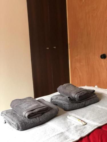 dos toallas sentadas en una cama frente a un espejo en Cabañas Refugio Huillinco, en Huillinco