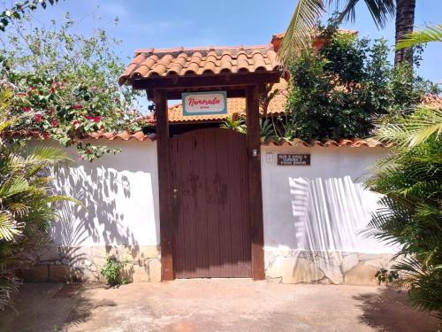 une porte en bois avec un panneau. dans l'établissement Namorada Brava Guest House, à Búzios
