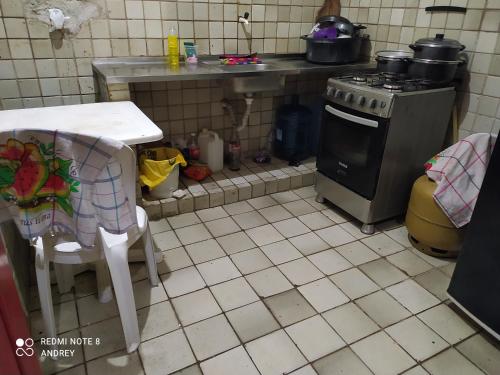 a kitchen with a table and a stove and a table and chairs at Marbelo Pernambuco in Recife