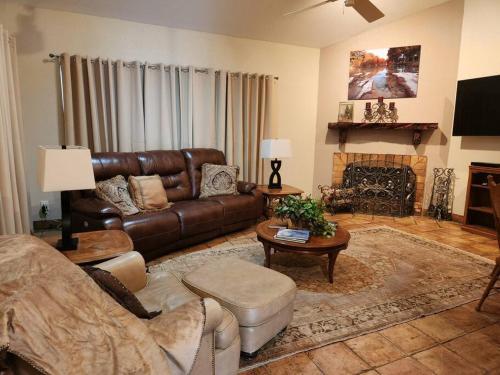 a living room with a leather couch and a fireplace at Casita #5 @ Riverhill in Kerrville