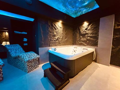 een bad in een kamer met een sterrenplafond bij MOZAIK Apartments & Spa - Modern Apartments with Exclusive Spa Wellness in the City Center, Free Parking, Wi-FI, Sauna, Jacuzzi, Salt Wall in Ćuprija