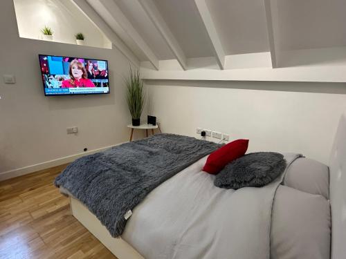 a bedroom with a bed with a flat screen tv on the wall at Moda Gibraltar - Central Location in Gibraltar
