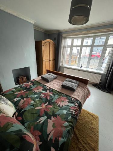 a bedroom with a bed with a floral bedspread at House near to CastleCourt shopping in Belfast