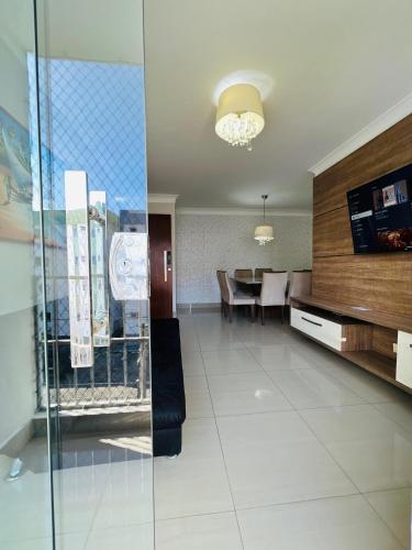 a living room with a table and a dining room at Descanso cond edifício tropical B in Maceió