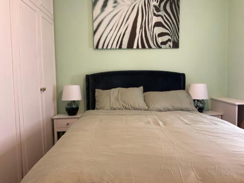a bedroom with a bed with a zebra painting on the wall at Maye house 
