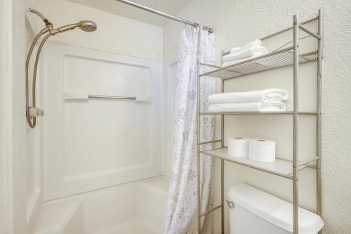 a bathroom with a shower and a toilet and towels at Pet-Friendly Home Near Downtown Albuquerque! in Albuquerque