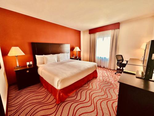 une chambre d'hôtel avec un lit et une télévision dans l'établissement La Quinta by Wyndham San Luis Potosi, à San Luis Potosí
