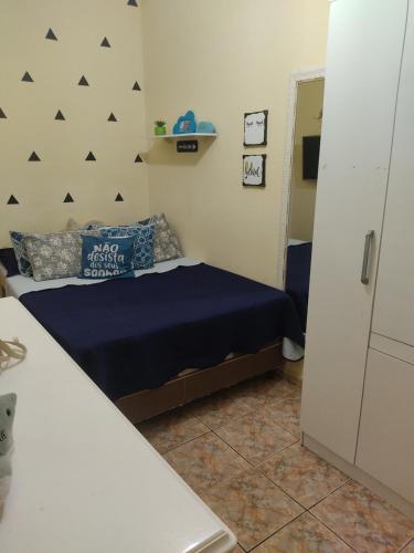 a bedroom with a bed with blue sheets and blue pillows at Casa famíliar in Rio de Janeiro