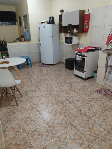 uma cozinha com um frigorífico e uma mesa em Casa famíliar no Rio de Janeiro