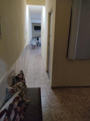 um corredor que leva a uma sala de estar com um sofá em Casa famíliar no Rio de Janeiro