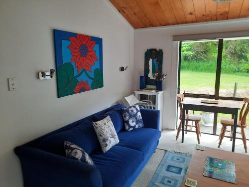 un soggiorno con divano blu e tavolo di Akatarawa Valley and River Retreat a Cosy Two Bedroom Guest Suite a Upper Hutt