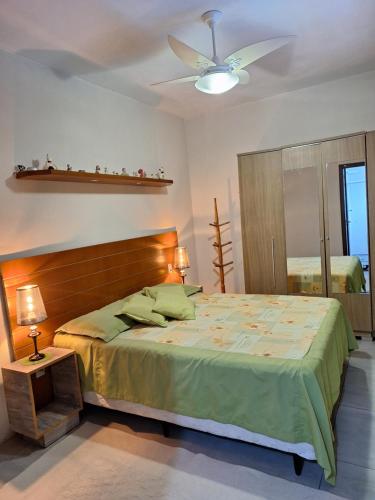 1 dormitorio con 1 cama y ventilador de techo en Recanto da Praia Paraíso, en Torres
