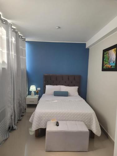 um quarto com uma cama com uma parede azul em CASA MARIA em Pisco
