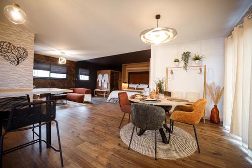 un salon avec une table et des chaises et une chambre dans l'établissement * L’Eden * Maison romantique avec balnéo et sauna, à Treize-Vents