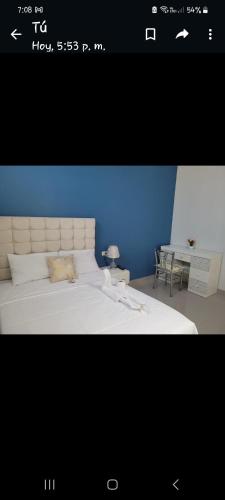 Una foto de un dormitorio con cama y escritorio en CASA MARIA, en Pisco