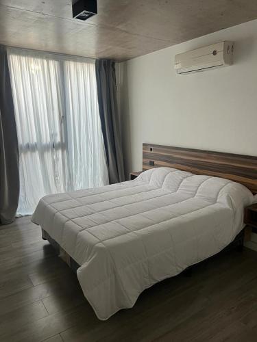 1 dormitorio con 1 cama grande frente a una ventana en Amar Azul en Balneario Mar Azul
