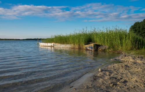 a boat sitting on the shore of a body of water at Villa Warchały in Narty