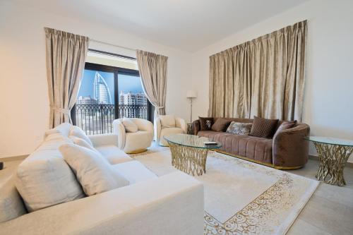 a living room with a couch and a table at 7 Star BurjAlArab Hotel View luxury 2 bdr apt with ammenities in Dubai