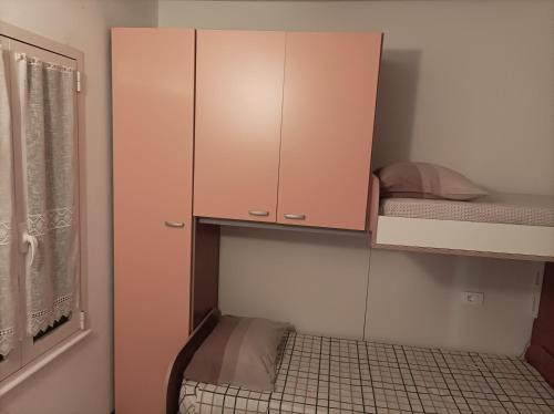 a small room with a cabinet and a bunk bed at Sal service Ibiscus Beach Ocean View Apartment in Santa Maria