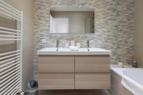 ein Bad mit einem Waschbecken und einem Spiegel in der Unterkunft "Casa Nonna" - 16 mn à pied du Palais, parking privé, clim, ascenseur in Cannes